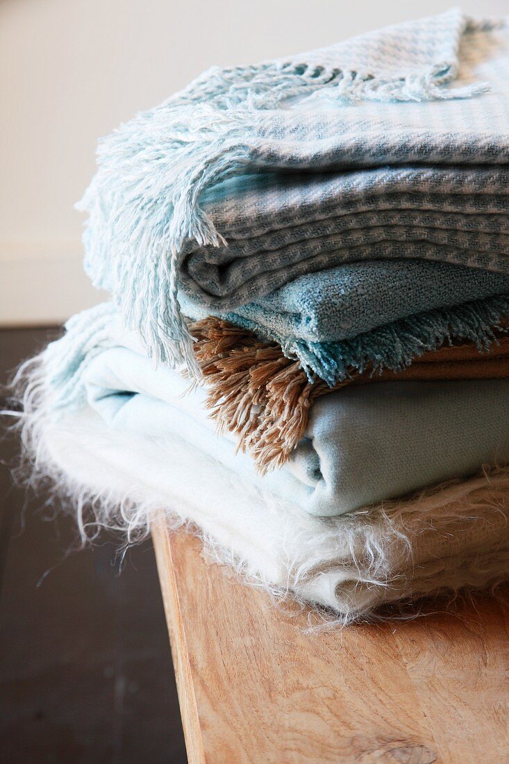 Stack of woollen blankets on table
