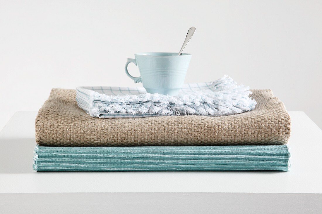 Tea cup on stack of table runners