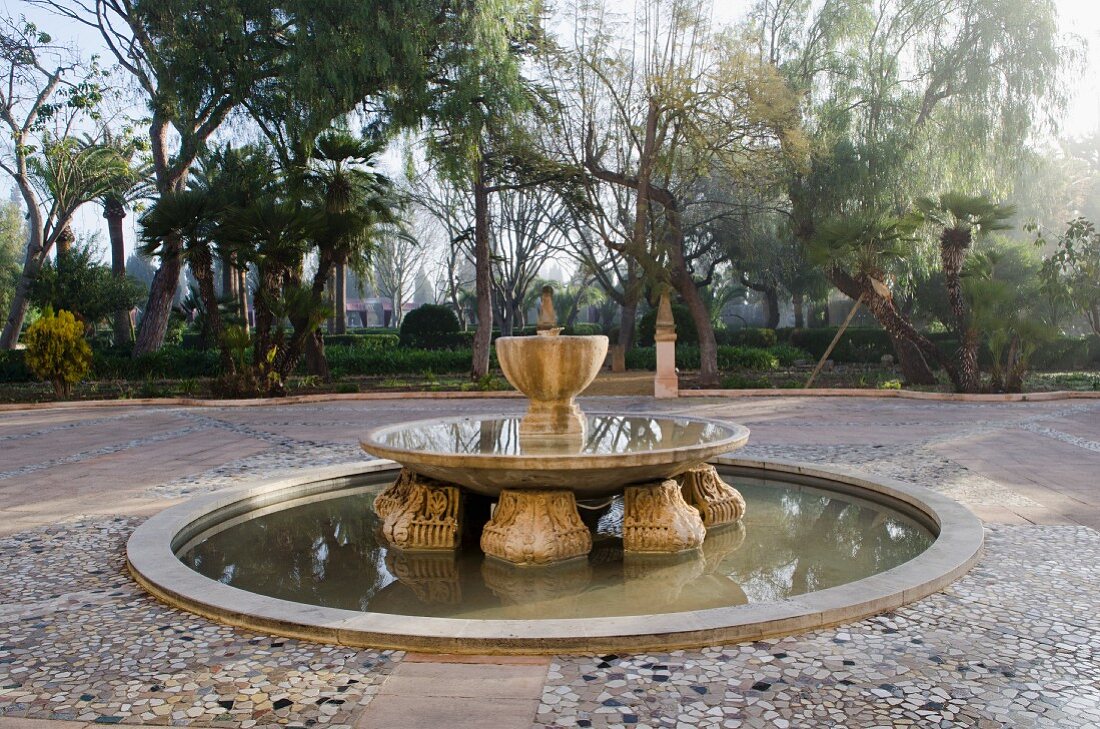 Courtyard with old, ornamental fountain in Mediterranean garden