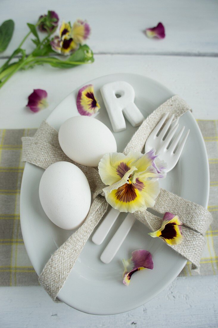 Tischgedeck dekoriert mit Stiefmütterchen & Eiern