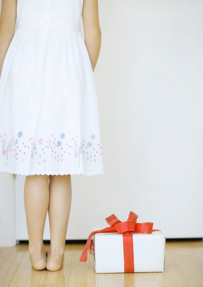 Girl standing next to gift
