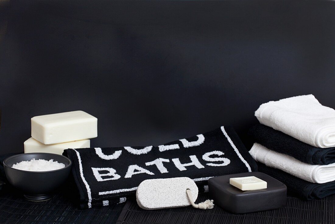 Simple, black and white spa decoration with soaps and lettering on towel