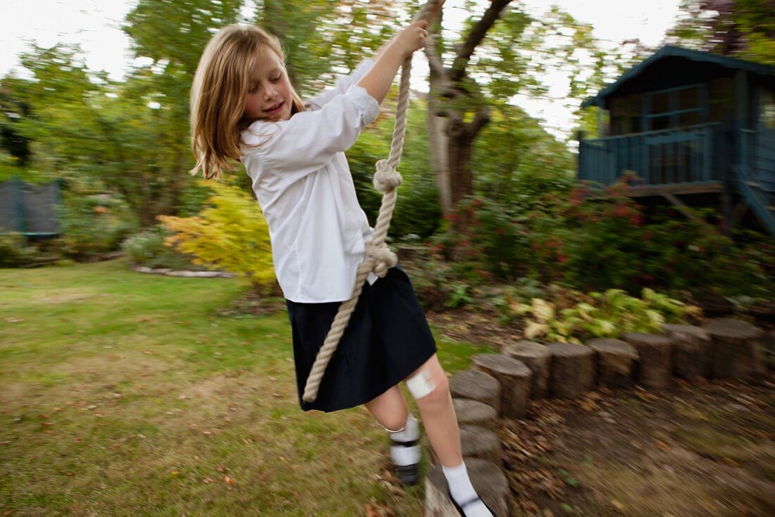 Mädchen spielt mit einem Seil im Garten
