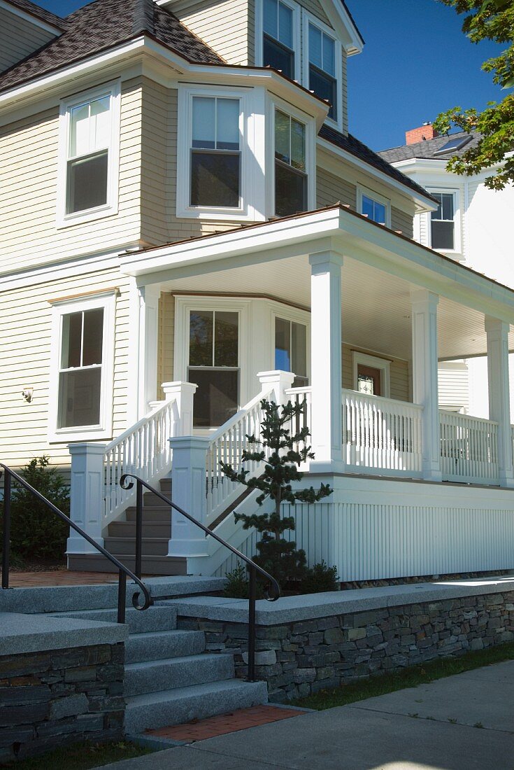 Amerikanisches Wohnhaus mit heller Holzfassade und Veranda