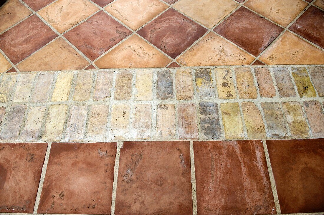 Fussboden mit Ziegelpflaster zwischen Terrakotta-Fliesen in verschiedenen Formaten
