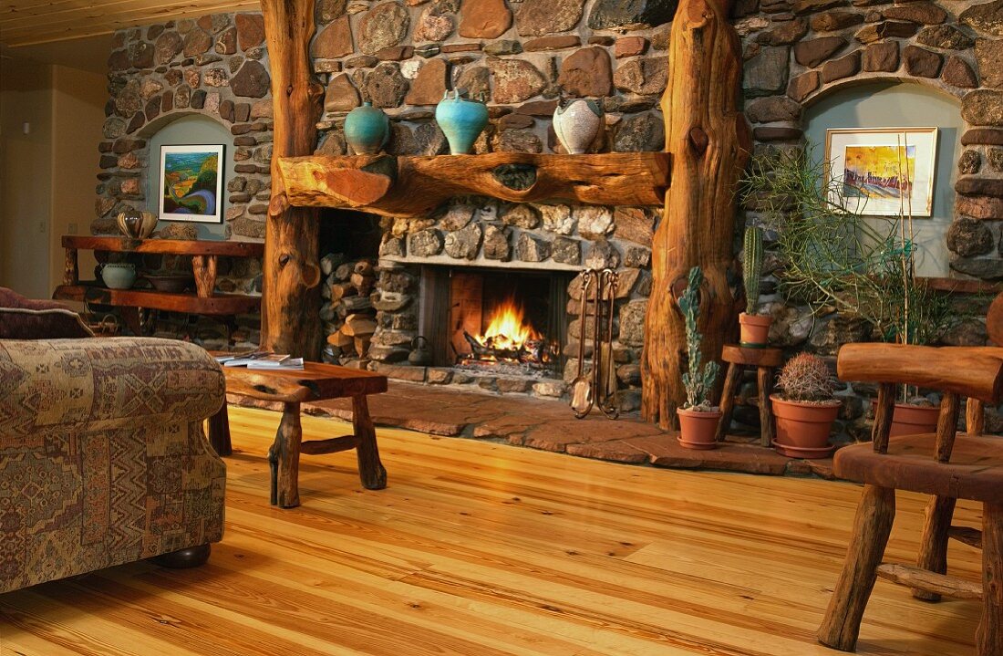 Warm living room with pine hardwood floors and stone wall