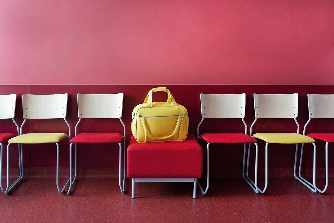 Stühle und eine gelbe Tasche in einem Wartezimmer