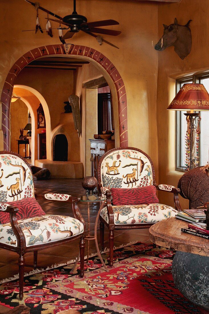 Gepolsterte Stühle mit folkloristischem Stoffbezug in rustikalem gelb getönten Wohnraum eines mexikanischen Landhauses