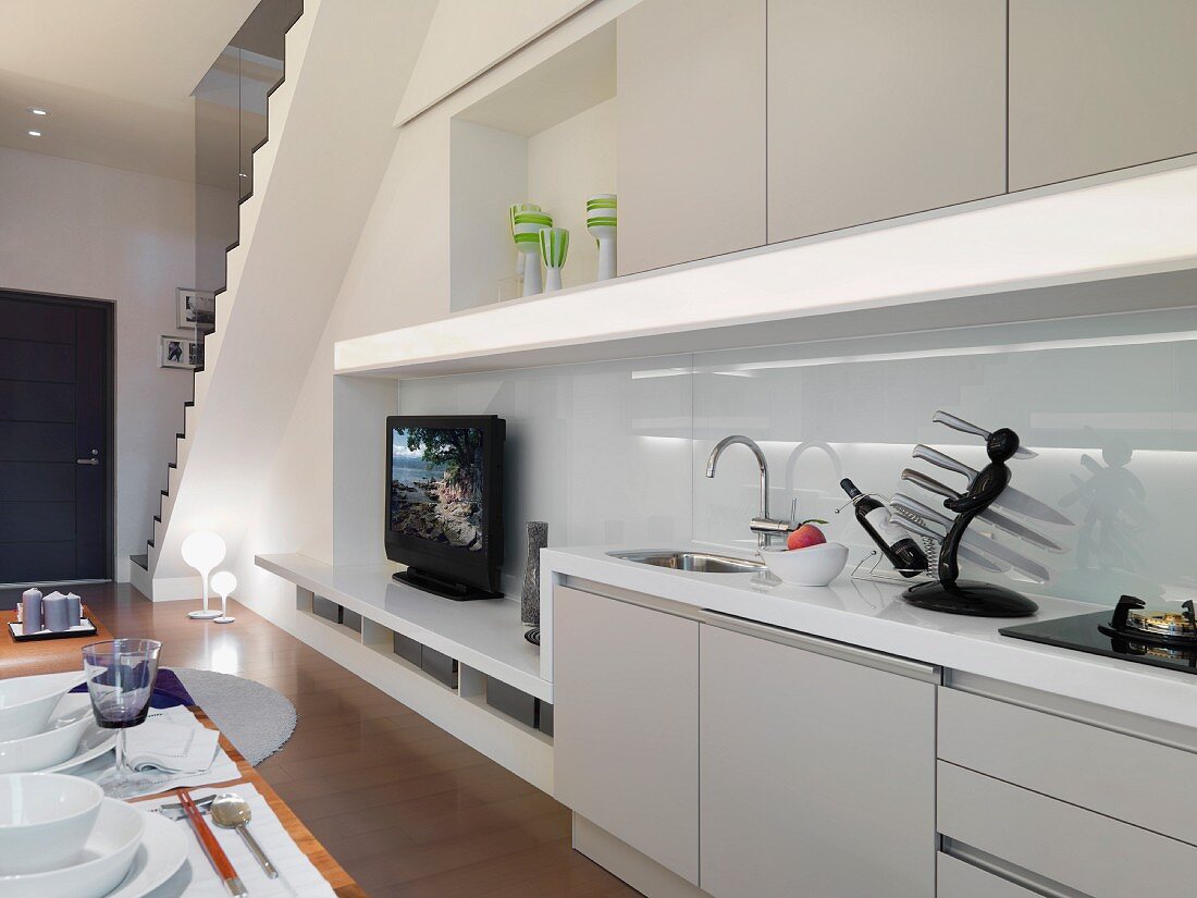 Offenes Wohn- und Esszimmer mit Einbauschrank und integrierte Küchenzeile unter Treppenaufgang