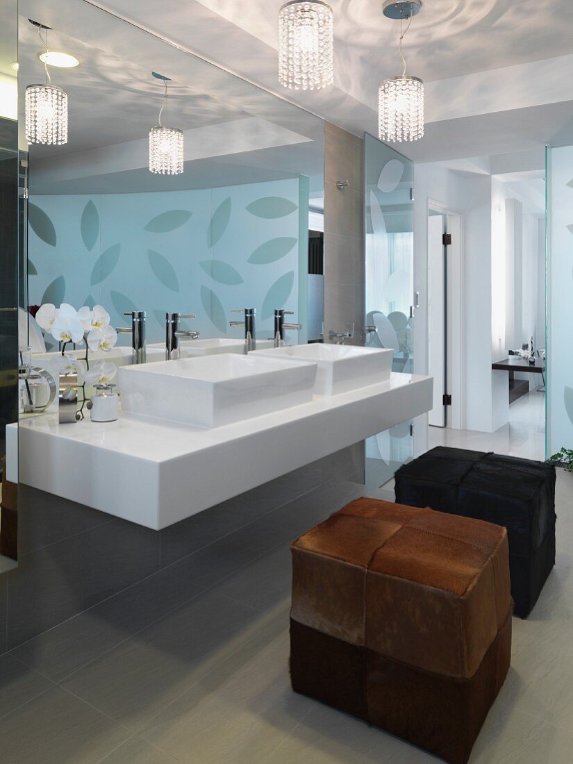 Sitzwürfel mit Fellbezug vor Designer Waschtisch mit Wandspiegel im Bad