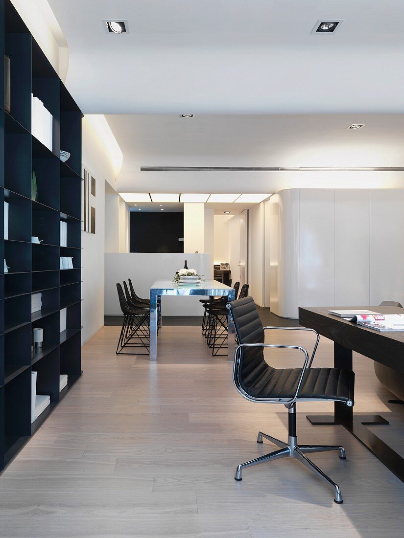 Offenes Wohnen - Arbeitsbereich mit Bürostuhl am Schreibtisch vor dunklem Wandschrank und Essplatz