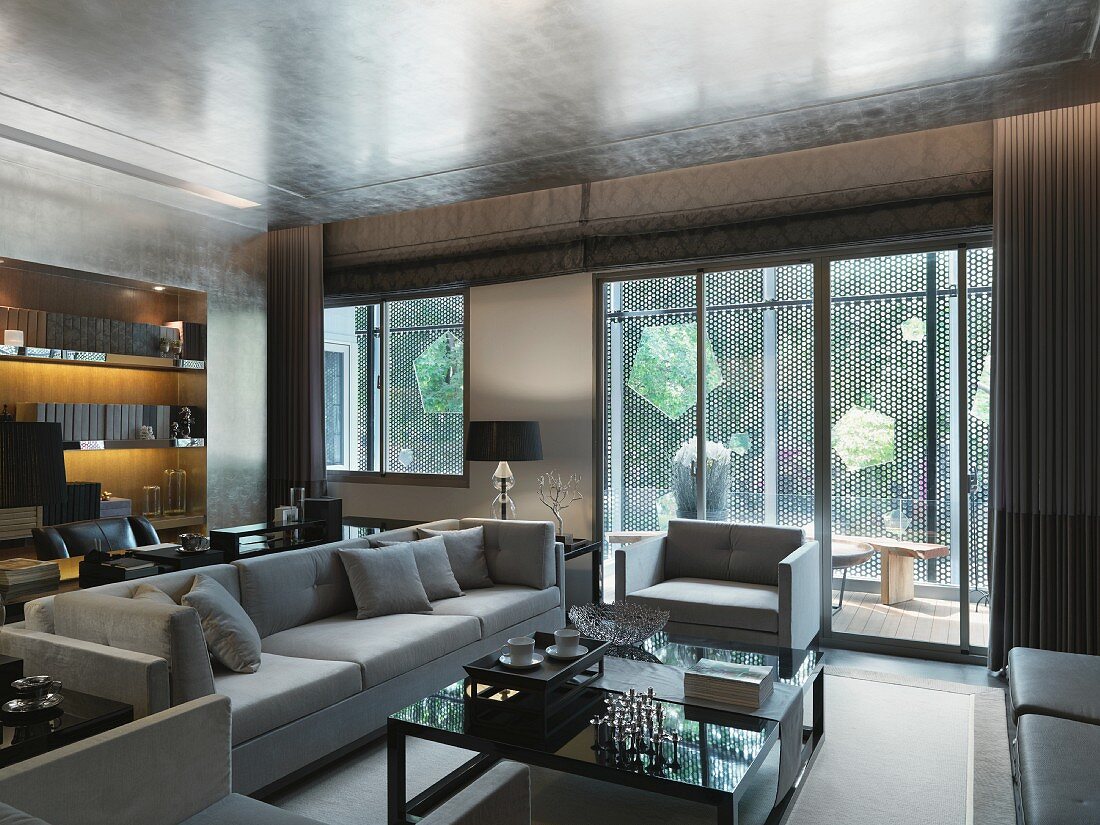 Eleganter Wohnraum mit Terrassentüren und helle Polstergarnitur vor Couchtisch in klassisch modernem Stil