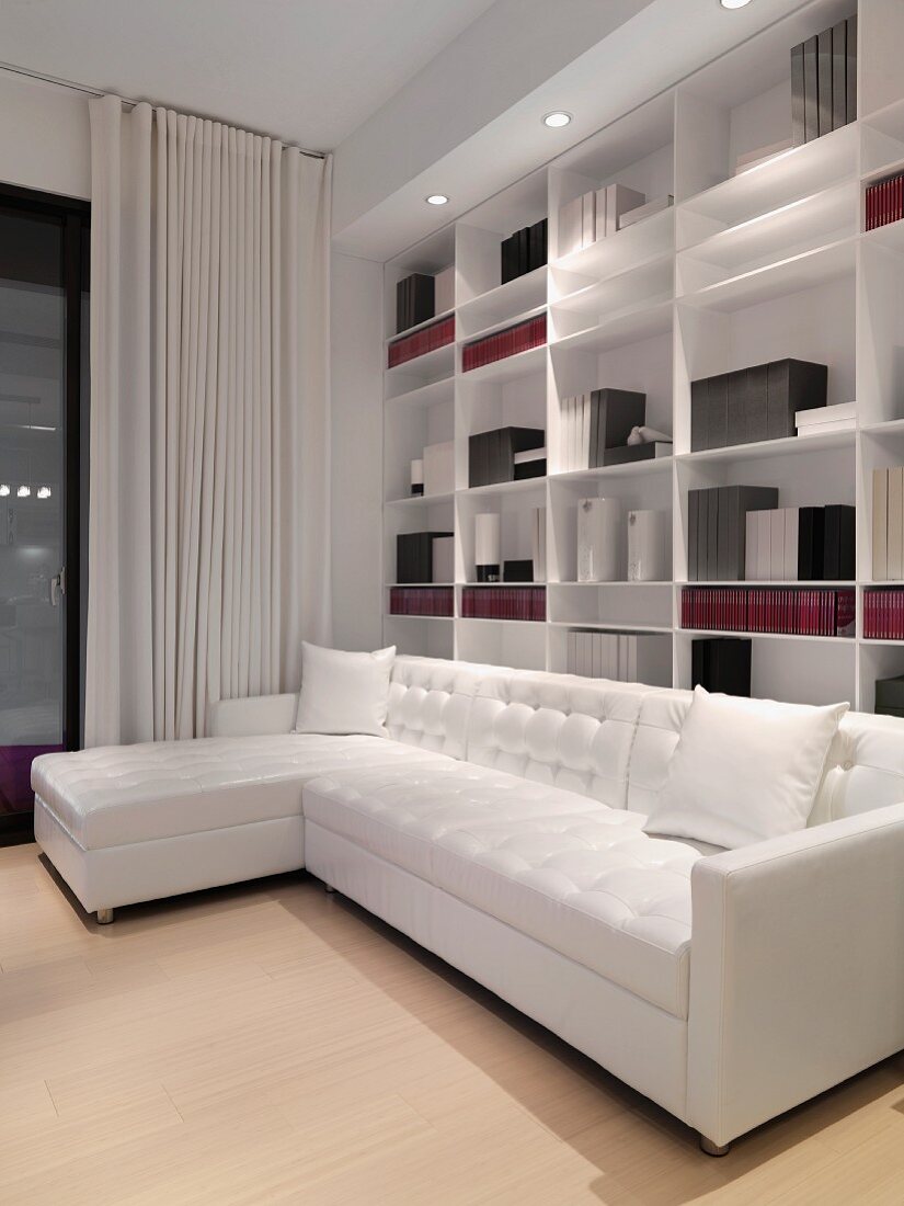 White sofa in front of wall bookcase