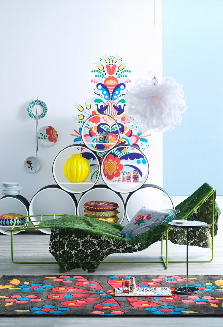Bright rug, metal couch and circular shelving units in front of colourful wall sticker