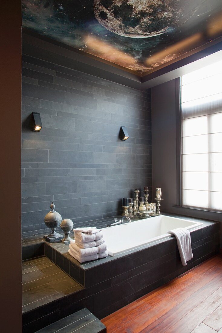 Modernes Bad - Badewanne vor Wand mit dunklen Schieferfliesen und sphärischer Bemalung an Decke