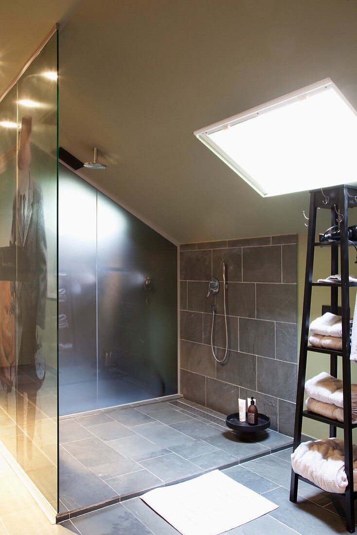 Modern attic bathroom - grey-tiled, wheelchair-accessible shower with glass screen