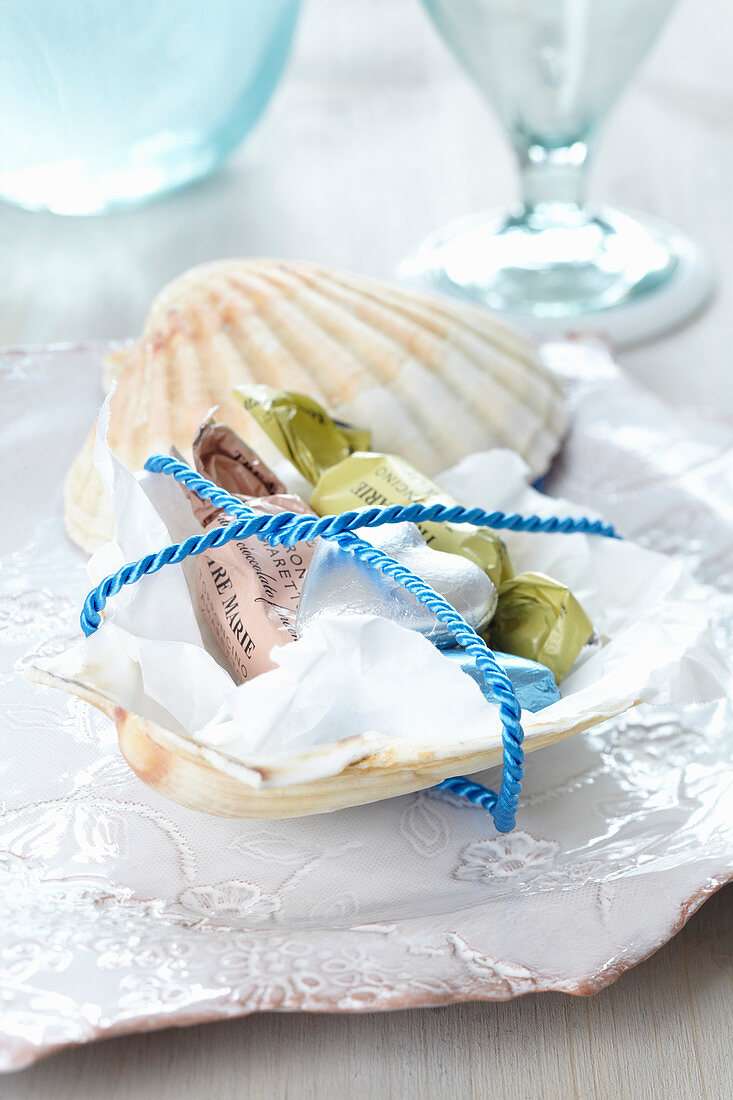 Gastgeschenk: Jakobsmuschelschale mit Süßigkeiten gefüllt und mit Seil verbunden