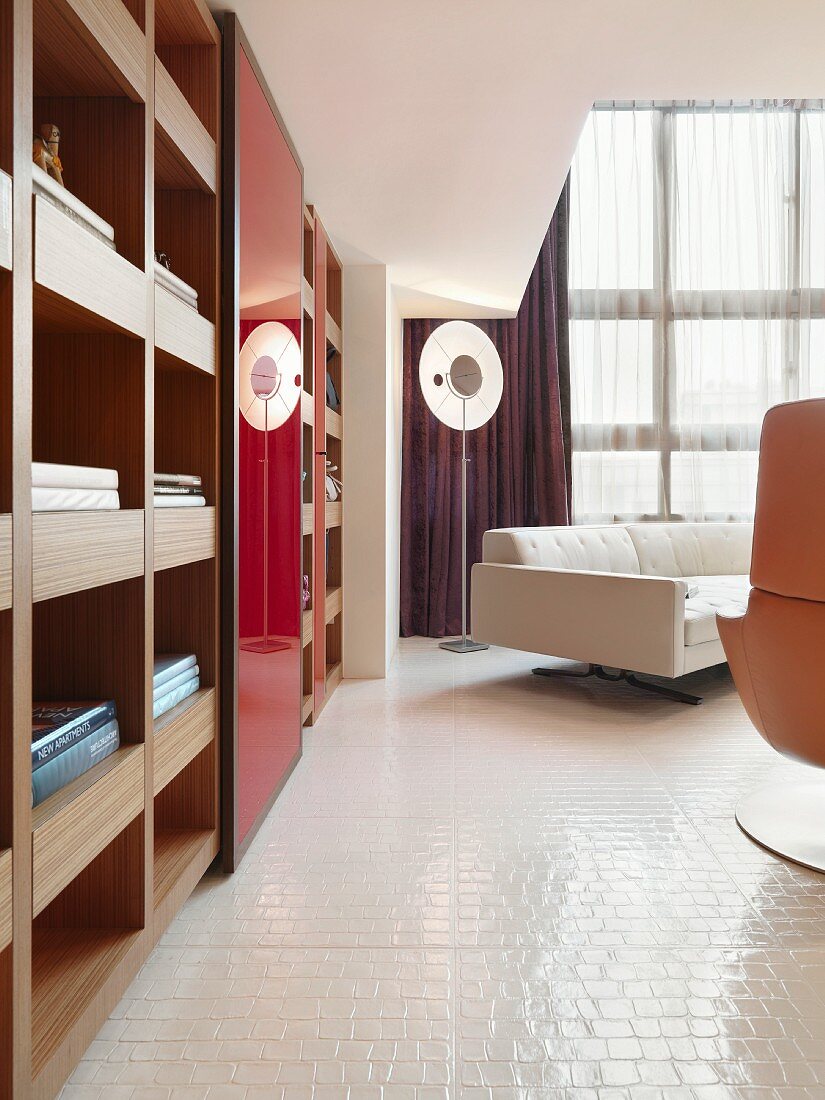 Einbauregal und Designermöbel im Wohnraum mit weissen Bodenfliesen