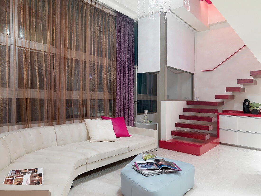 Sofa combination with upholstered ottoman and staircase with red floating treads in contemporary interior
