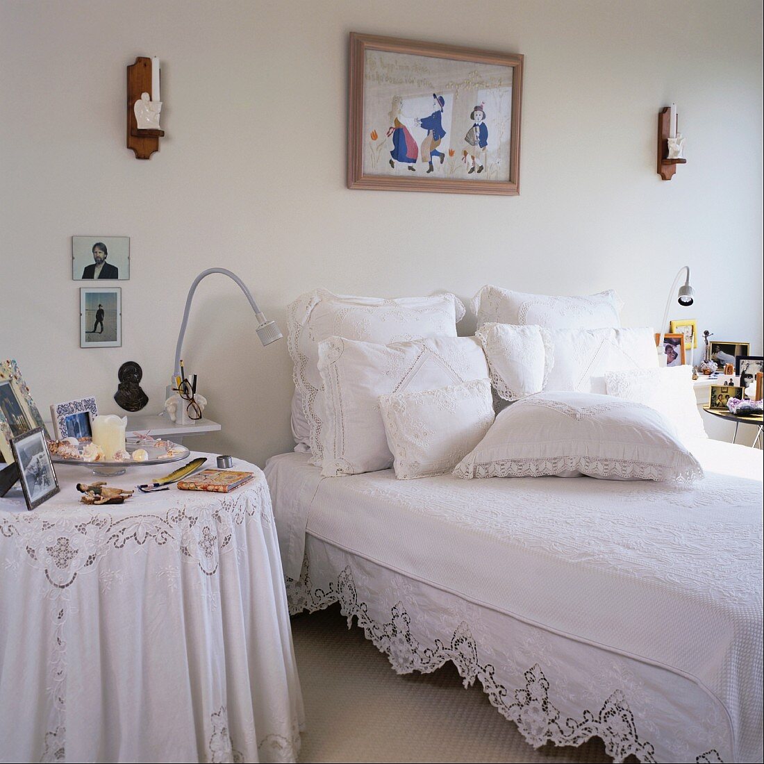 Doppelbett mit Vintage-Bettwäsche mit Spitzenbesatz und vielen verschiedenen Kissen in Weiß