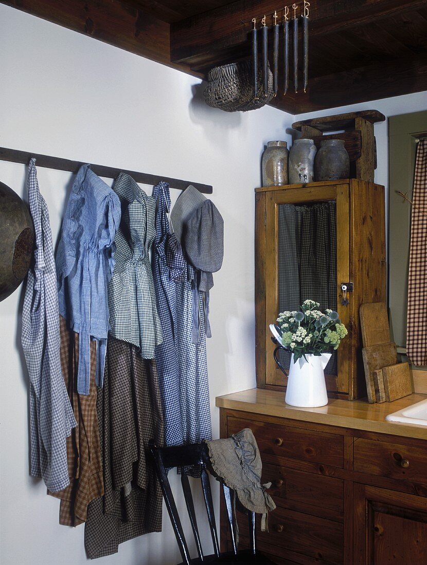 Antique clothing from 1850 hanging decoratively in kitchen with vintage furnishings