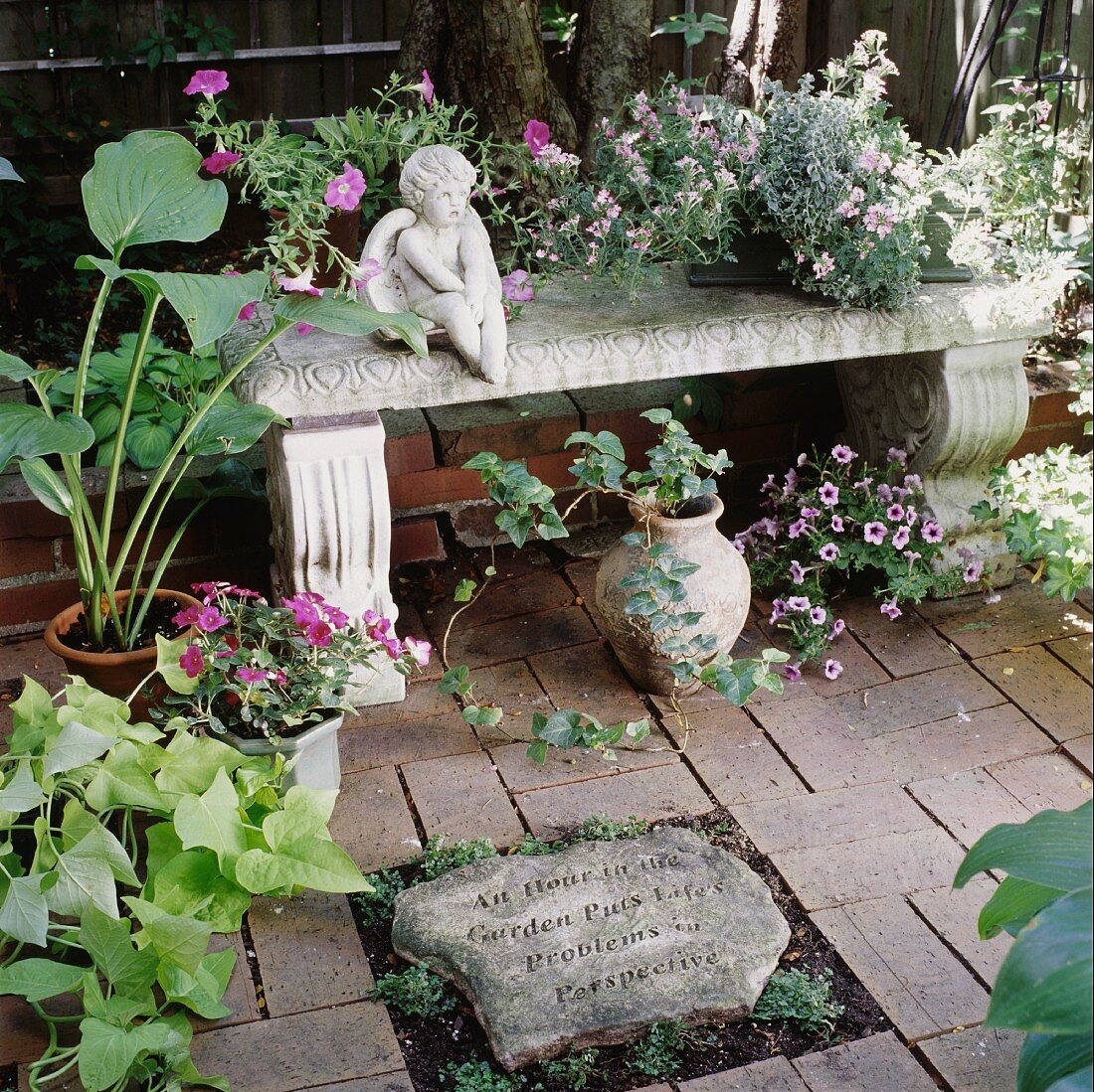 Dekorative Steinbank mit Blumentöpfen und einer Engelsfigur
