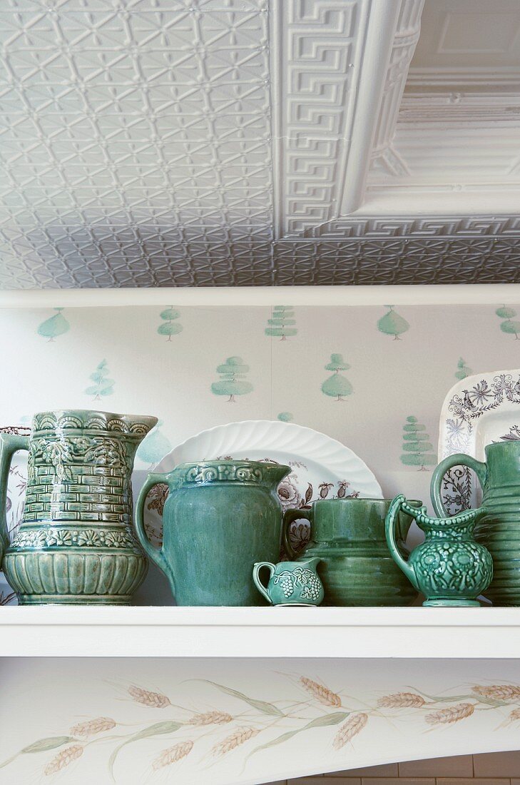 Green ceramics on shelf below stucco ceiling