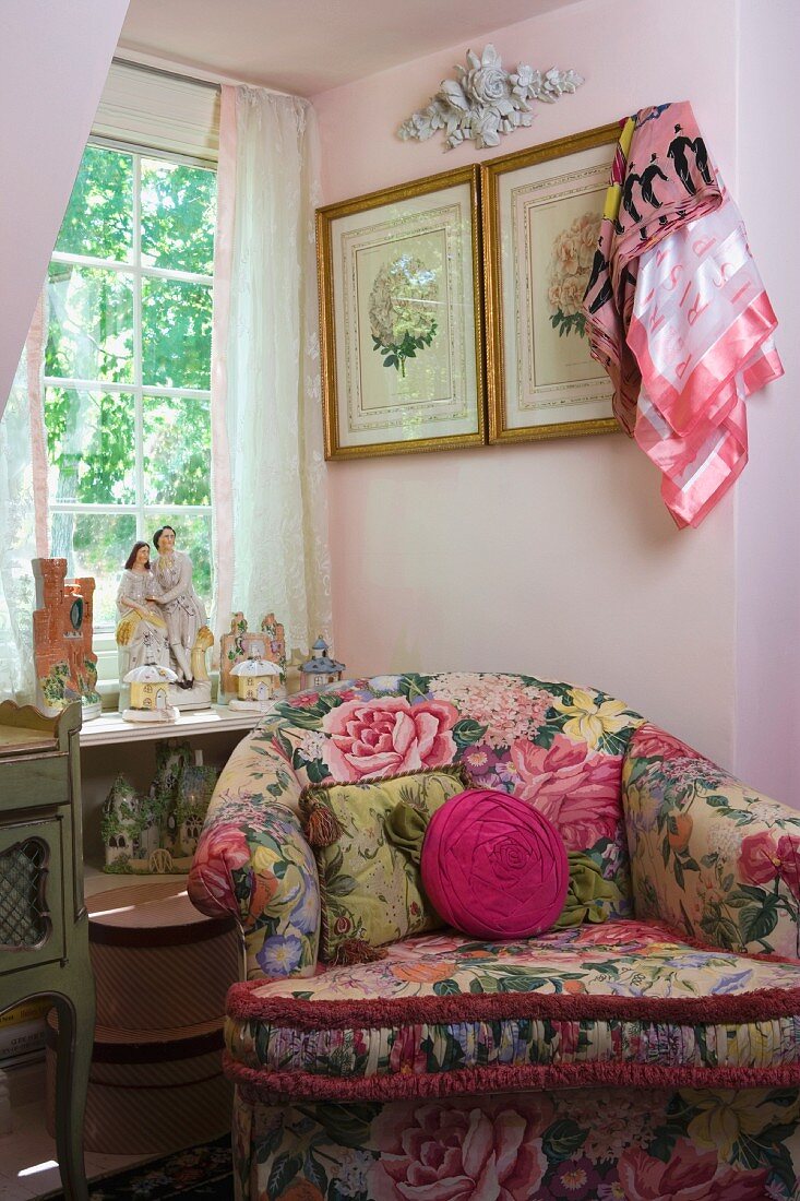 Behaglicher Sessel mit auffallendem Blumenmuster unter dem Fenster