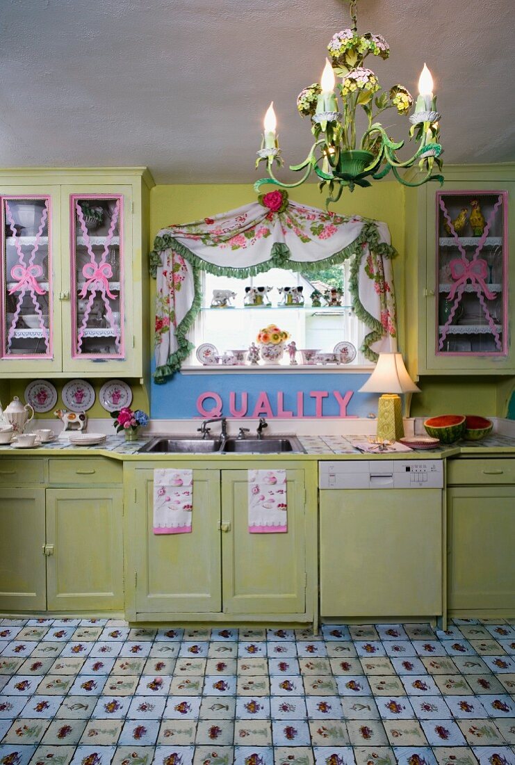 Dramatic, vintage kitchen with pink accessories and lino flooring designed to look like tiles