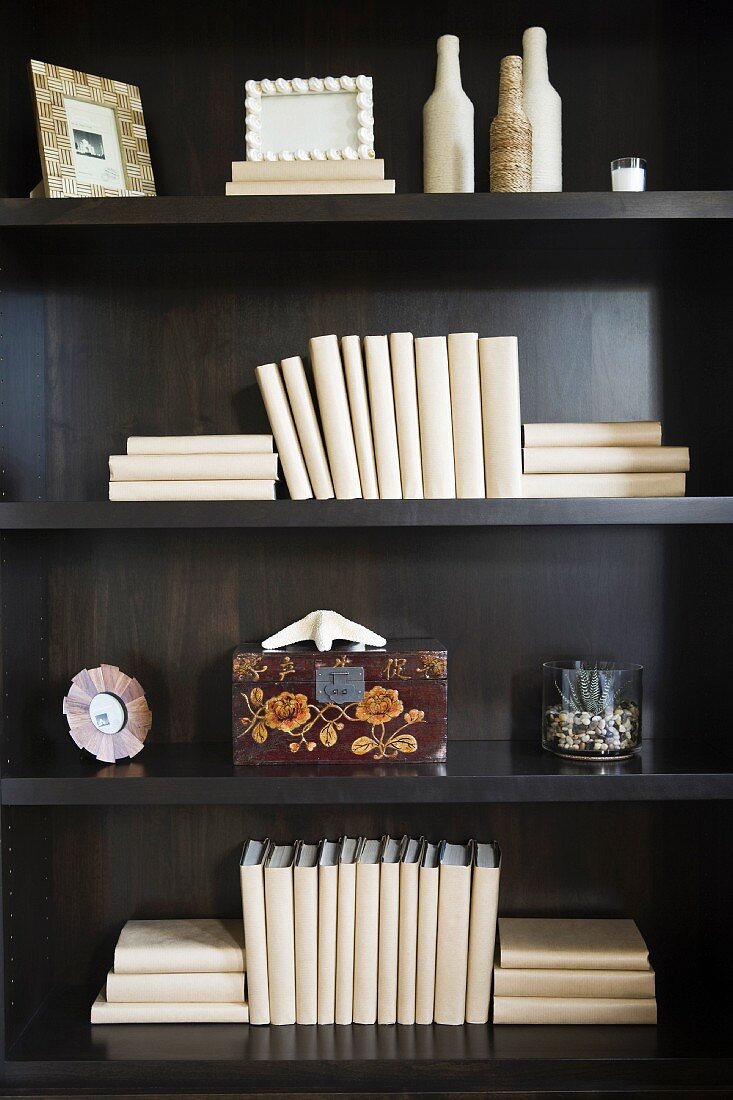 Blank books and decorations on wooden bookshelf