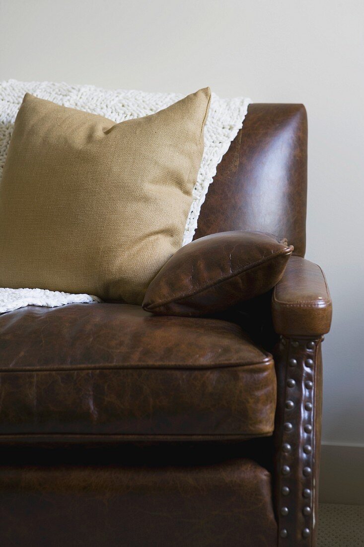 Brown leather sofa with throw pillows
