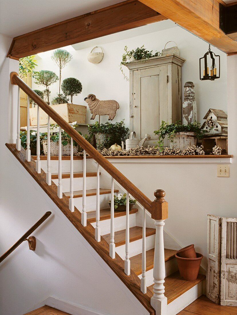 Staircase in country house with shelf and cabinet decorated with plants and gardening utensils