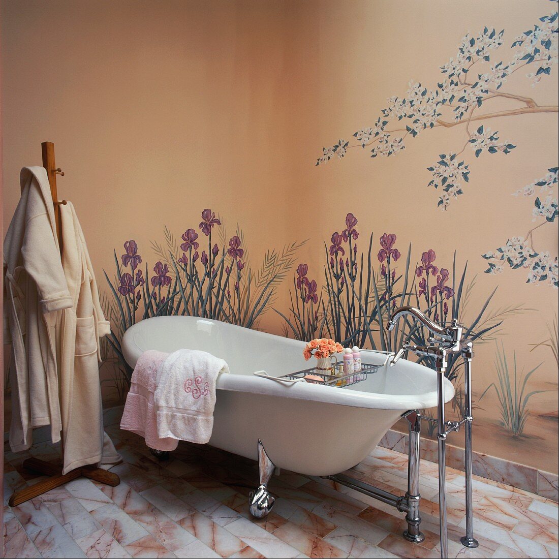 Free-standing bathtub against wall painted with garden flowers