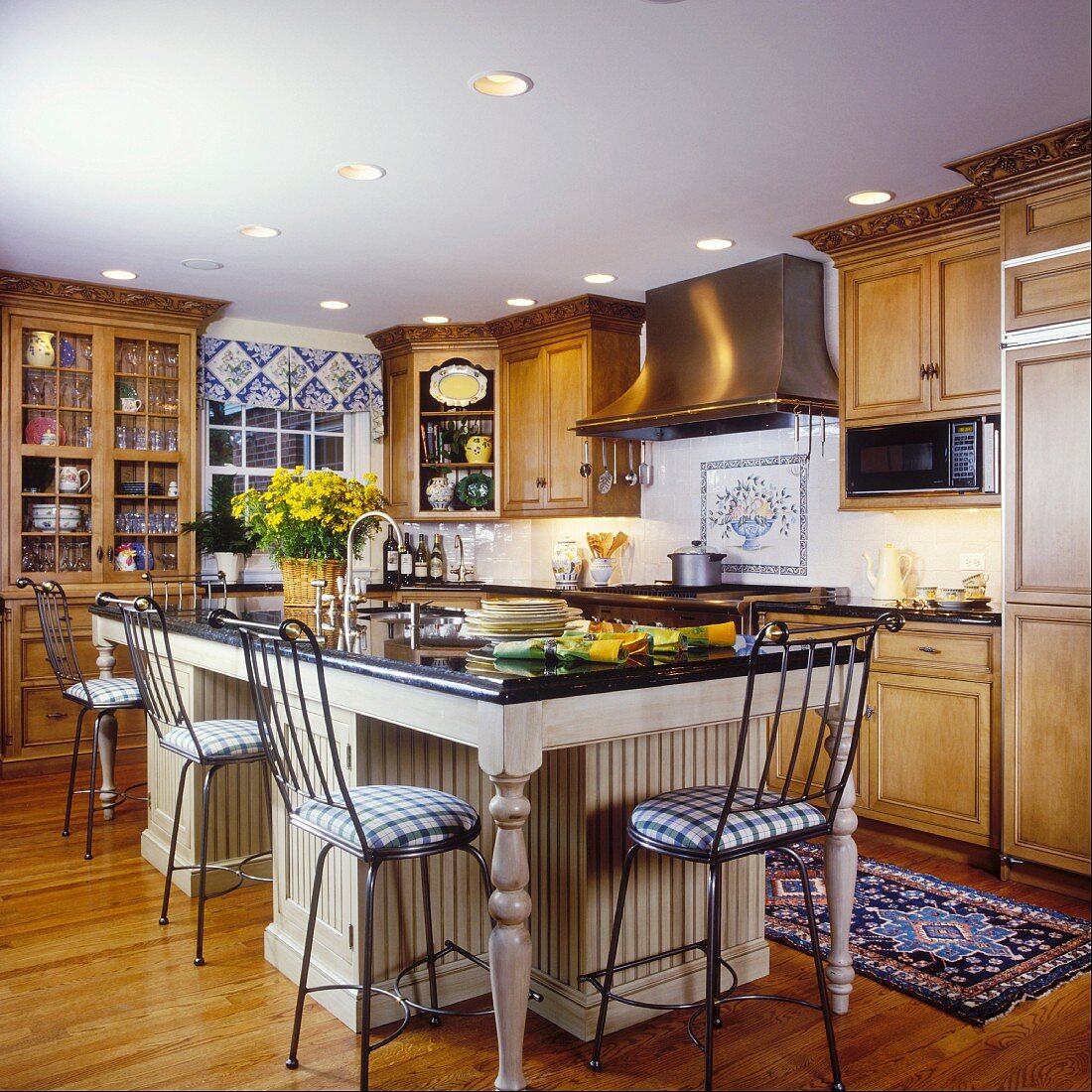 Traditionelle Küche mit Küchenblock im Esstischlook und hohe Stühle als Barhocker für die Küchentheke