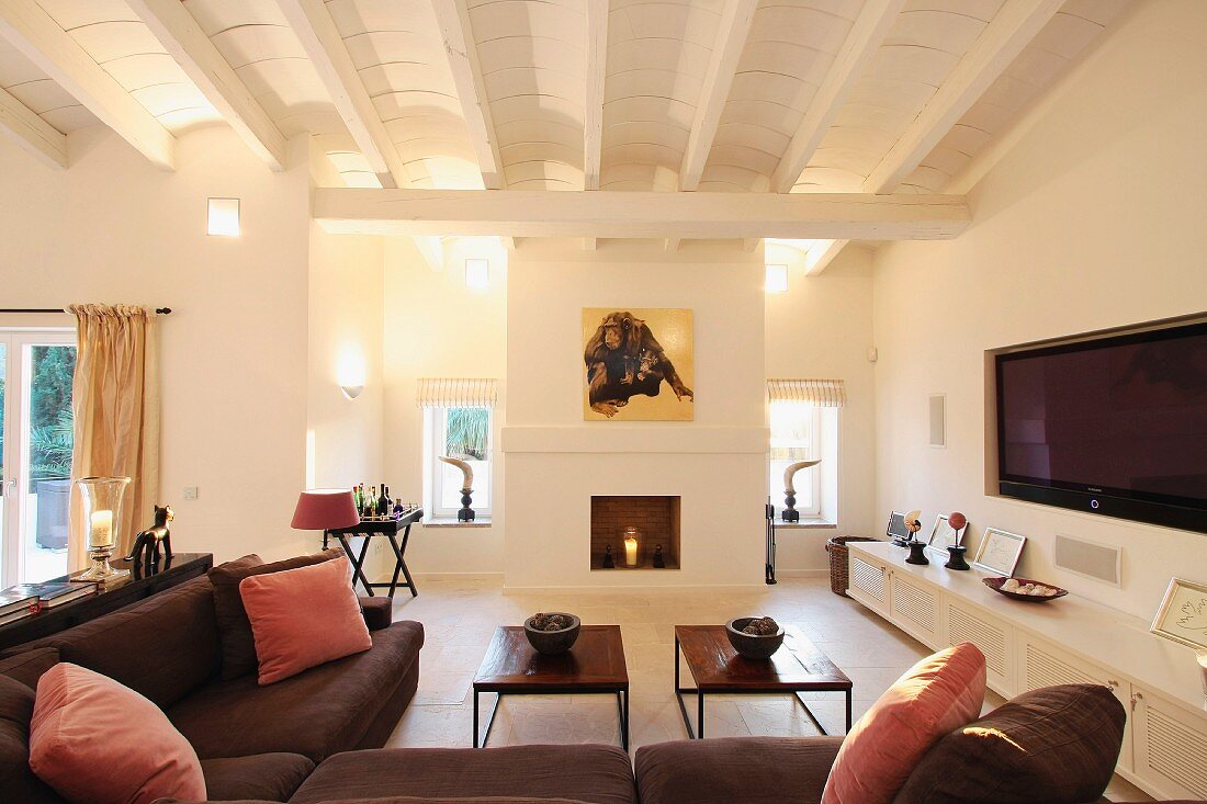 Braunes Sofa übereck und schlichte Couchtische in klassisch modernem Wohnraum mit Rippendecke