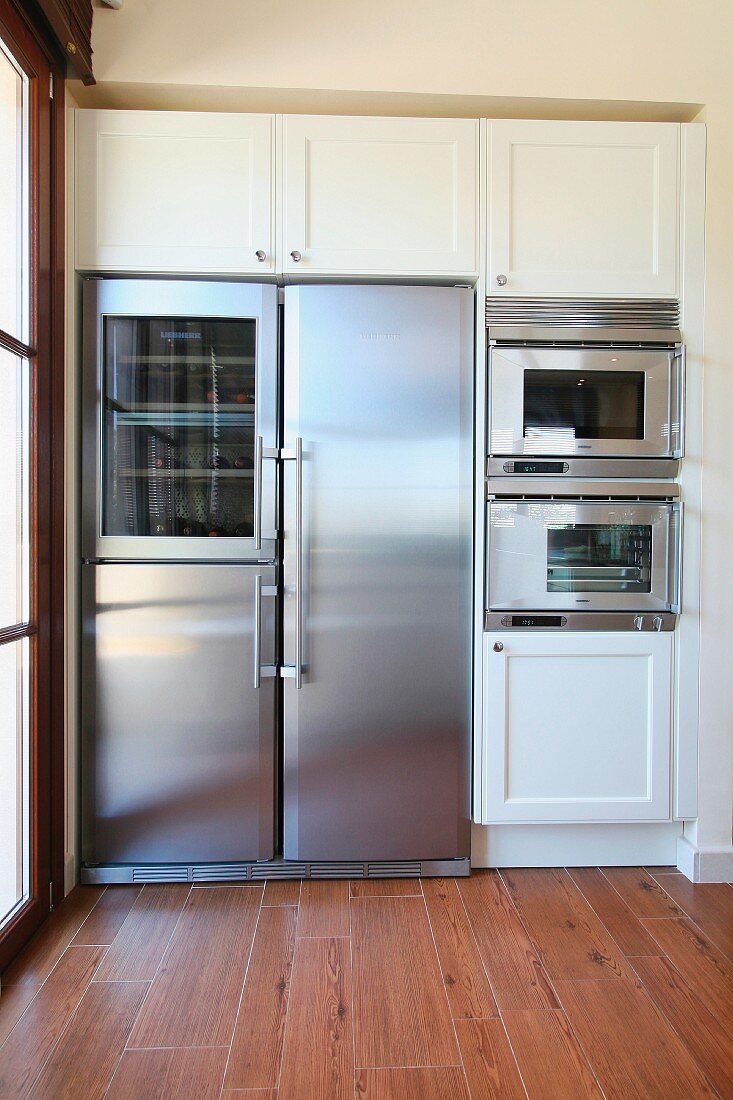 Stainless steel fridge surrounded by cabinets