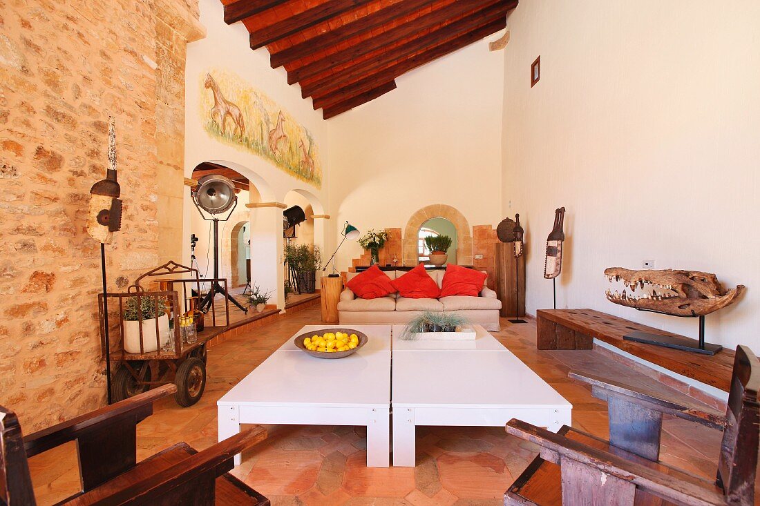 Offener Wohnraum mit modernem Couchtisch und antiken Stühlen in mediterranem Landhaus