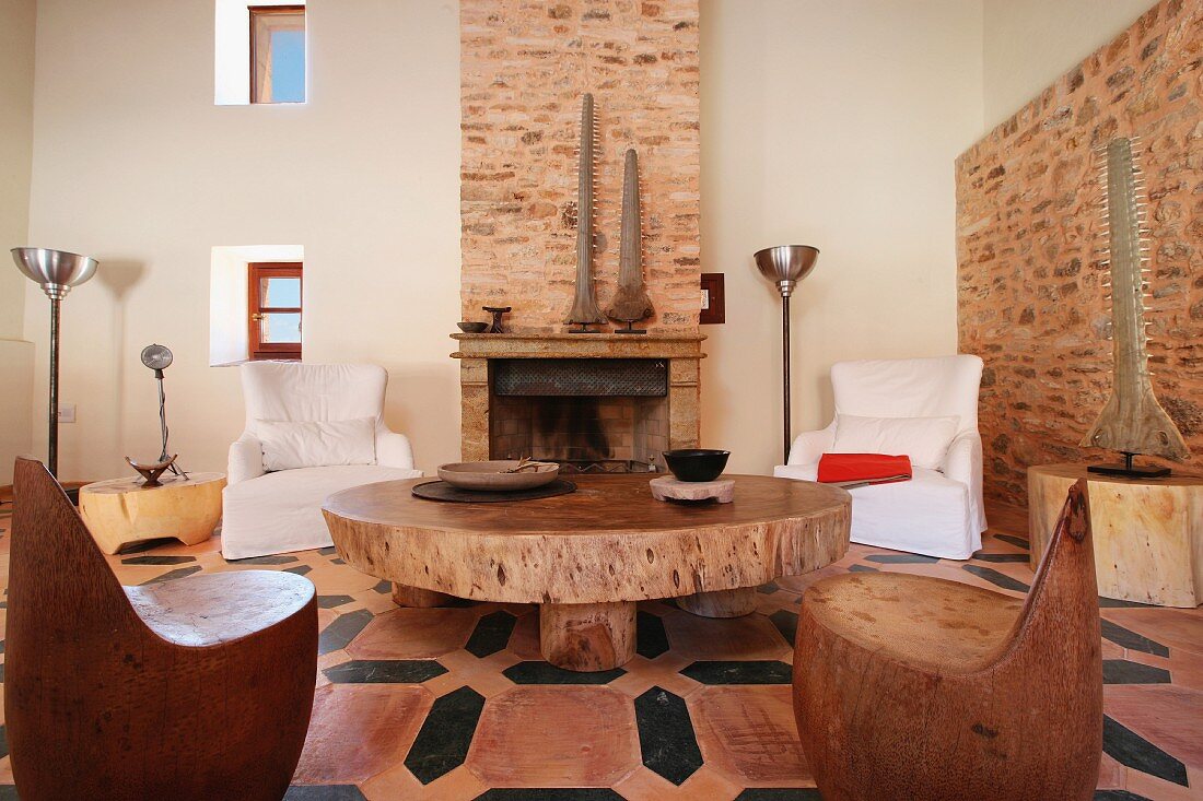 Stühle aus Massivholz und rustikaler Couchtisch vor Kamin in renoviertem Landhaus
