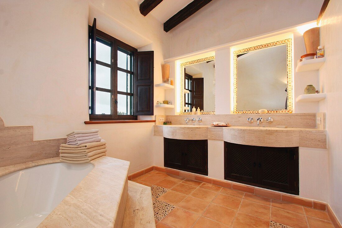 Elegantes Bad eines mediterranen Landhauses mit Waschtisch und Spiegel in Nische eingebaut