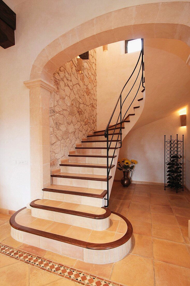 Geschwungener Treppenaufgang im Vorraum einer mediterranen Villa