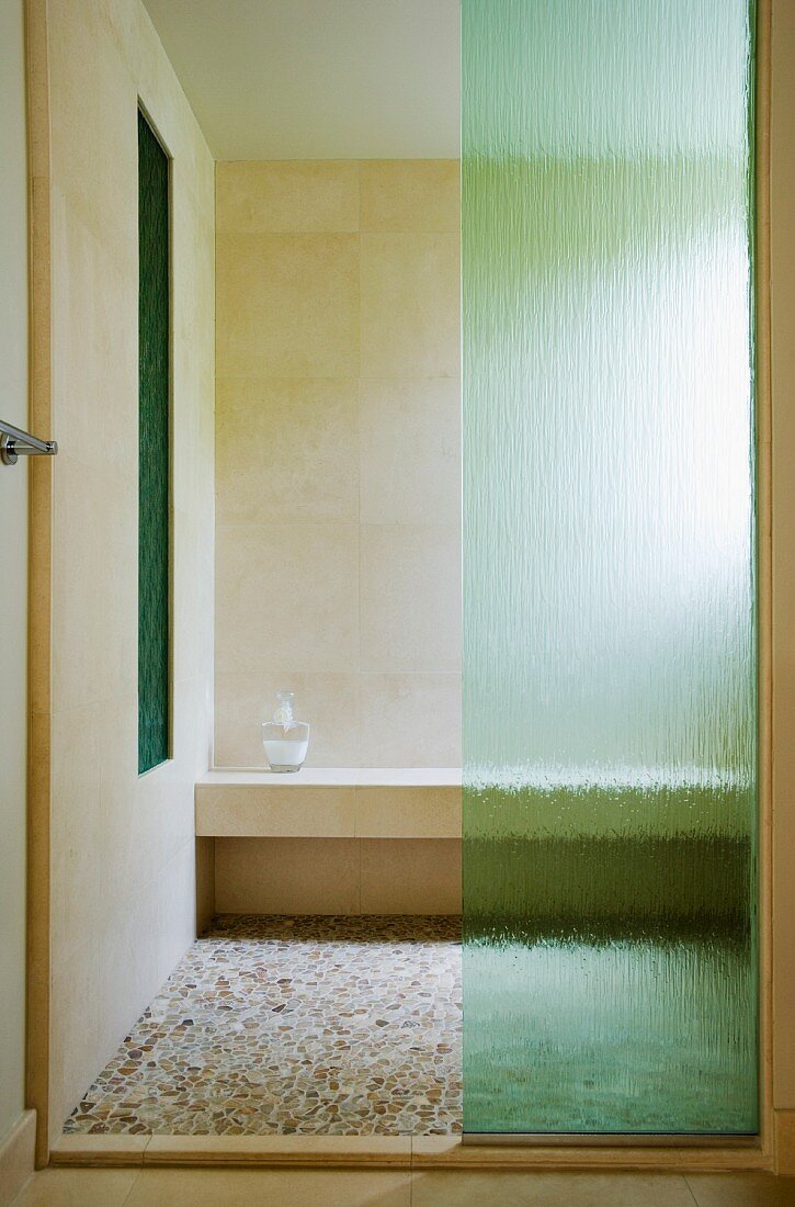 Eine Duschkabine mit Bruchsteinmosaik und grünem Glas