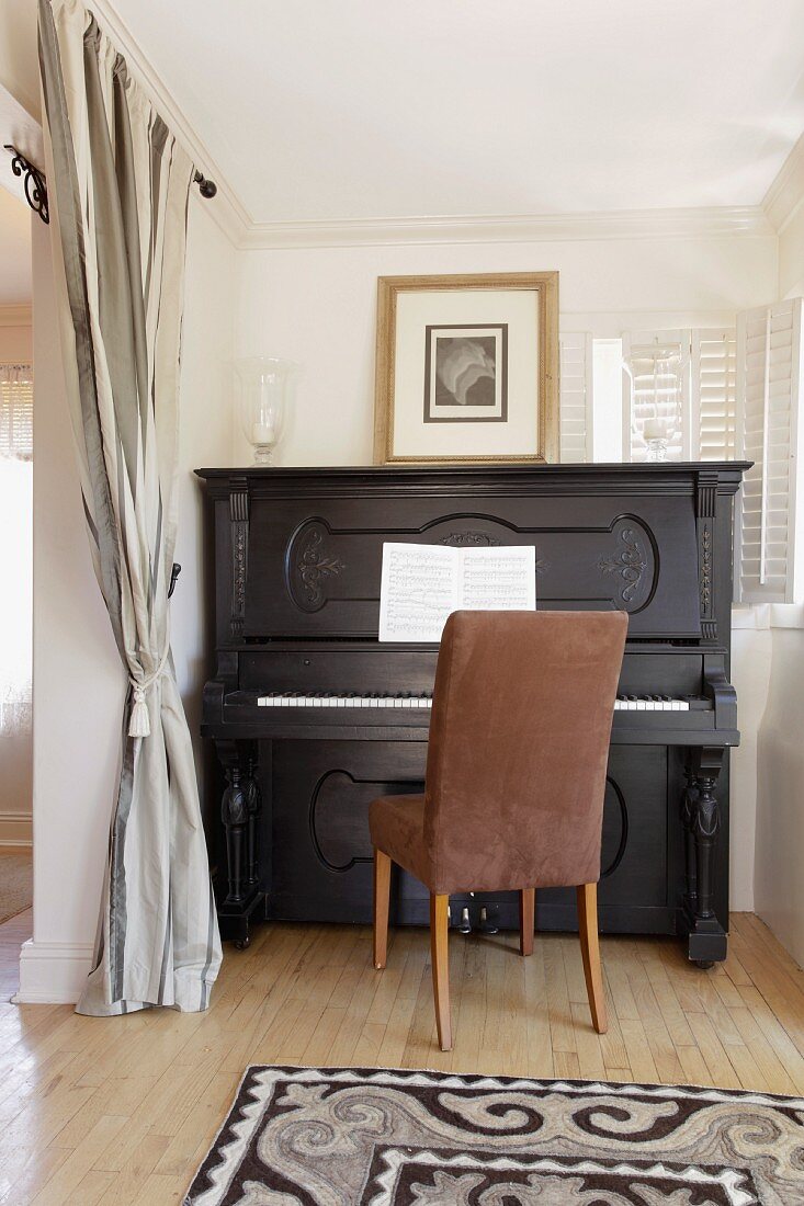 Black upright piano in home