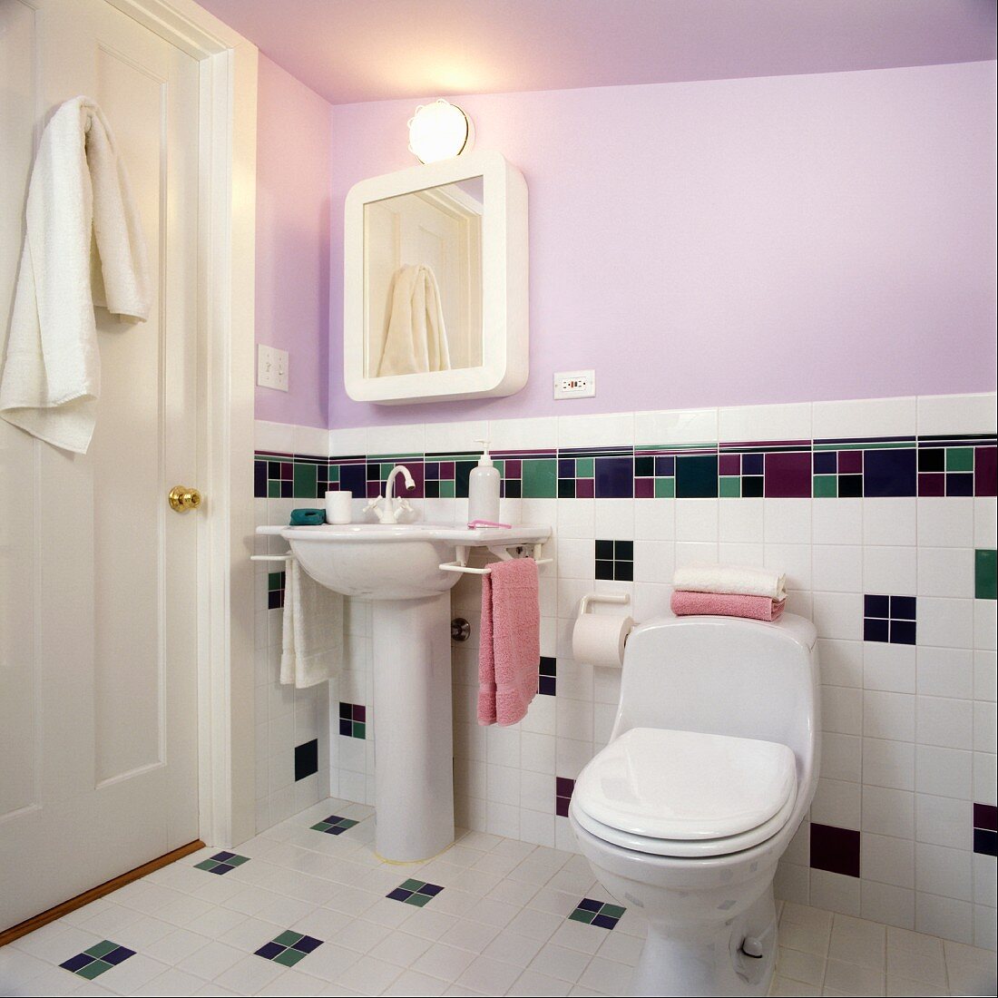 Sink and toilet in bathroom with lavender wall