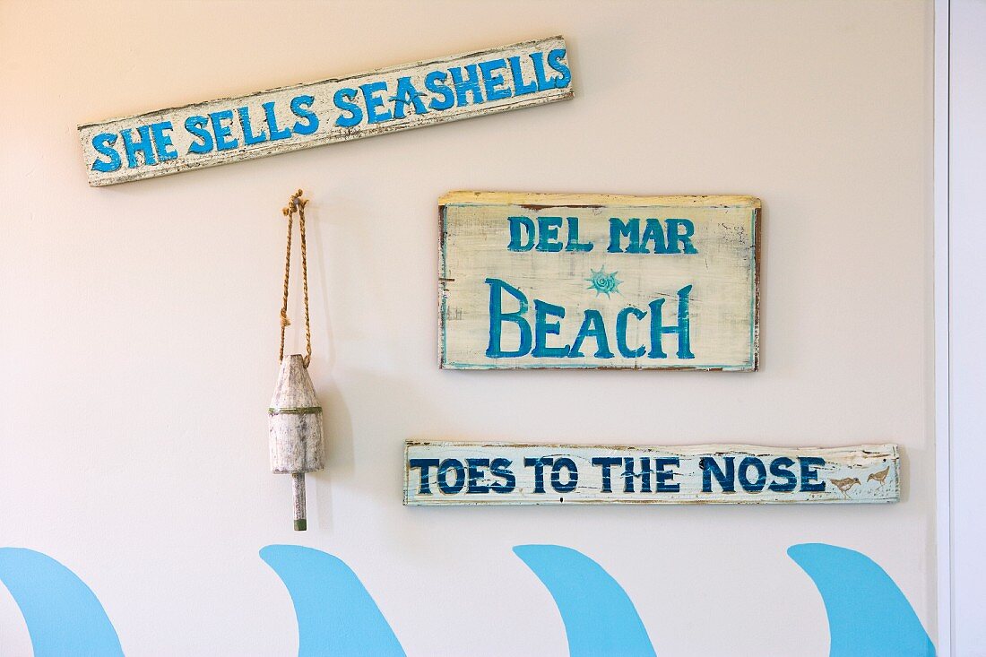Decorative beach signs hanging on wall