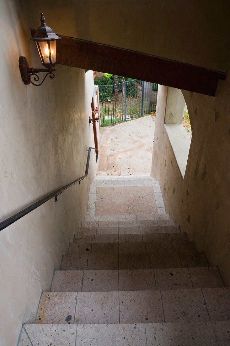 Blick nach unten auf gemauerte Aussentreppe mit Wandleuchte im traditionellen Laternenstil