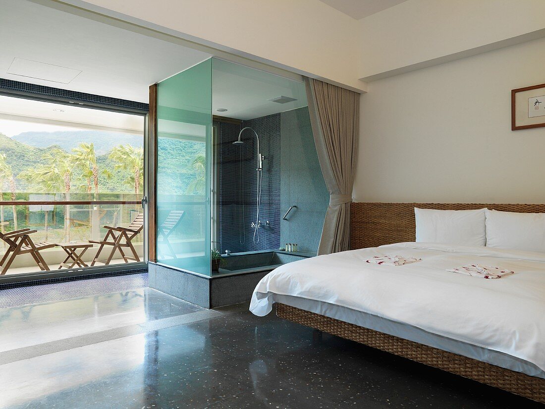 Modern bedroom with glass shower and outdoor patio