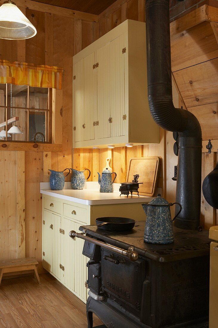 Alter Kaminofen in Küche einer rustikalen Holzhütte