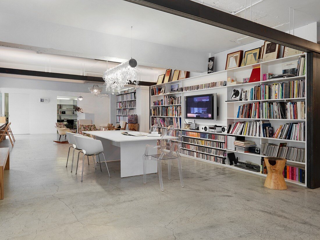 Essbereich im offenen Wohnraum mit durchgehender Bücherwand