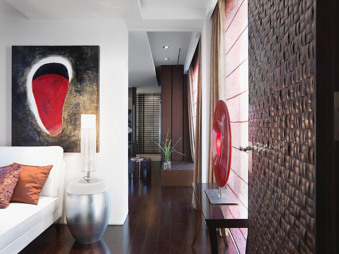Wohnraum mit einem Fussboden aus Edelholz und modernen Kunstobjekten