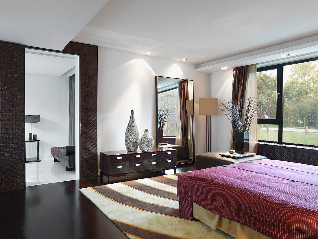 Großräumiges, modernes Schlafzimmer mit großem Doppelbett und einem gemusterten Teppich